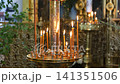 Burning candles on a golden candelabrum in an orthodox temple for spiritual prayer 141351506