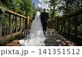 Newlyweds walking on wooden bridge, celebrating marriage and a new journey together 141351512