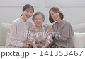 A three-generation family of women sitting on a sofa A three-generation family of women sitting on a sofa 141353467