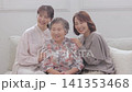 A three-generation family of women sitting on a sofa A three-generation family of women sitting on a sofa 141353468