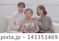 A three-generation family of women sitting on a sofa A three-generation family of women sitting on a sofa 141353469