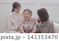 A three-generation family of women sitting on a sofa A three-generation family of women sitting on a sofa 141353470
