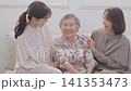 A three-generation family of women sitting on a sofa A three-generation family of women sitting on a sofa 141353473