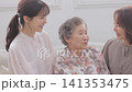 A three-generation family of women sitting on a sofa A three-generation family of women sitting on a sofa 141353475