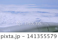 Aircraft wing is seen above fluffy white clouds and blue sky, illustrating the smooth transition from clear air to cloud cover during flight 141355579