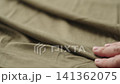 Slow motion man hand checking green cotton jersey cloth 141362075