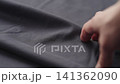 Slow motion man hand checking blue cotton jersey cloth 141362090