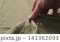 Slow motion man hand checking green cotton jersey cloth 141362093
