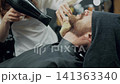 Barber Drying Client Beard In Barbershop 141363340