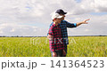 Father and son walk through golden wheat field while experienced farmer shares knowledge and guidance. Authentic family farming scene represents agricultural heritage mentorship and future generations 141364523