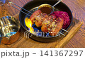 the sausages are burning bright bonfire, flames. Close-up. Sausages are fried on hot grill. Flame burns sausages, trapping juicy juices in them. Frying sausages on fire. camping 141367297