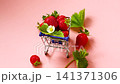strawberries in small grocery cart on light pink background 141371306