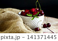 Fresh harvested cherries on wooden table with dark background 141371445