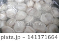 Boiling dumplings in a pot of water, showcasing the gradual cooking process with bubbles rising and dumplings floating to the surface in a kitchen setting 141371664