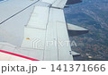 Aircraft wing with extended flaps and ailerons in flight over a landscape, showcasing the transition of aerodynamic components during ascent or descent 141371666