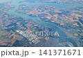 Aerial view of winding river flowing through patchwork farmland and urban areas, showcasing the natural landscape and human development in the region 141371671