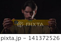 Hands holding yellow spirit level horizontally while worker checks alignment in low-key studio with soft blur, dark background, and precise measuring detail, with level, spirit, tool, hand detail 141372526