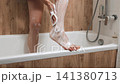Close-up view of soaping female feet in bathroom 141380713