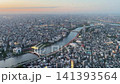 Aerial high-angle footage captures a panoramic evening view of Tokyo city from the Tokyo Skytree observation deck. The camera overlooks the winding Sumida River with its iconic Sakurabashi. 141393564