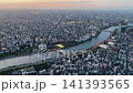 Aerial high-angle footage captures a panoramic evening view of Tokyo city from the Tokyo Skytree observation deck. The camera overlooks the winding Sumida River with its iconic Sakurabashi 141393565