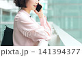 オフィス街でスマートフォンで話す女性・ビジネスウーマン 141394377