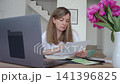 Worried woman checking bills and receipts while sitting at table with laptop. Stressed person planning home budget. Concept of personal finance review, expense control and household budgeting 141396825