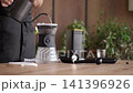 Rinsing paper filter for pour over coffee, pouring hot water from a gooseneck kettle into a coffee dripper. Concept of manual brewing and coffee preparation. 141396926