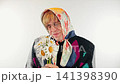 Comic portrait of a cross dressing man as old lady holding flowers 141398390