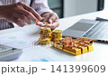 Investor Hands Stacking Counting Gold Coins and Bullion Bars on Desk. Secure Financial Investment and Wealth Preservation Concept. 141399609