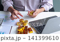 Investor Hands Stacking Counting Gold Coins and Bullion Bars on Desk. Secure Financial Investment and Wealth Preservation Concept. 141399610