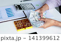 Wealthy Entrepreneur Counting Cash Next to Gold Bullion. Financial Investment Concept with Cash Money and Gold Bars.  141399612