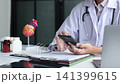 Doctor using mobile health app to review cardiovascular patient data in office. 141399615