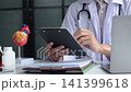 Medical practitioner cardiologist reviewing medical records in office. 141399618