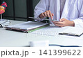 Male doctor using digital tablet for telehealth video consultation at clinic desk. Concept for telehealth or telemedicine. 141399622