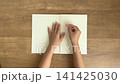 A child's hand peeling a pink sticky note from a notebook (4K silent video) 141425030
