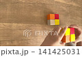 A child's hands place four more blocks on top of four blocks at once. (4K) 141425031