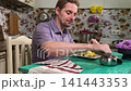 A mam is tasting food at home kitchen 141443353