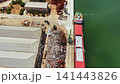 Cargo ship is being loaded with scrap metal at a port near a processing facility during a sunny day 141443826