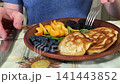 A mam is tasting food at home kitchen 141443852