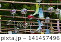 Glass wind chimes swaying in the breeze, filmed in slow motion, tilt 141457496