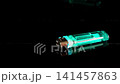 Lighter placed on a black surface with green color highlight at night 141457863