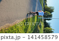 Young person pushing a bicycle on a path in a sunny park 141458579
