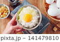 Egg over rice: A breakfast of white rice and a raw egg served in a bowl. 141479810