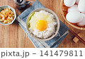 Egg over rice: A breakfast of white rice and a raw egg served in a bowl. 141479811