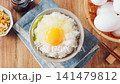 Egg over rice: A breakfast of white rice and a raw egg served in a bowl. 141479812
