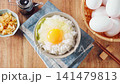 Egg over rice: A breakfast of white rice and a raw egg served in a bowl. 141479813