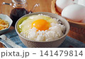 Egg over rice: A breakfast of white rice and a raw egg served in a bowl. 141479814