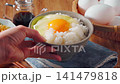 Egg over rice: A breakfast of white rice and a raw egg served in a bowl. 141479818