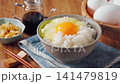 Egg over rice: A breakfast of white rice and a raw egg served in a bowl. 141479819