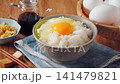 Egg over rice: A breakfast of white rice and a raw egg served in a bowl. 141479821
